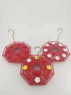 Red saucer hummingbird feeder with flower ports